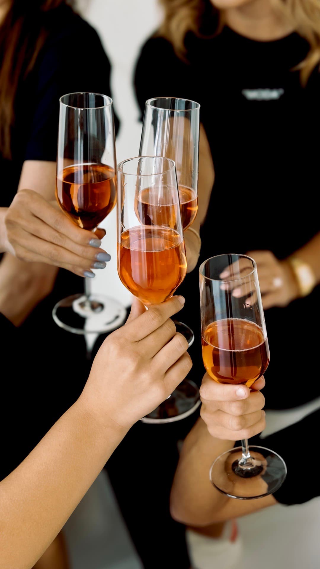A group in Moda shirts raising champagne glasses in a toast