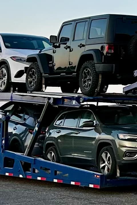 Open car transport carrier loaded with vehicles