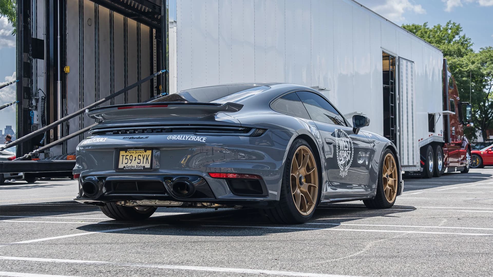 Exotic car secured on a soft-tie ramp for enclosed transport