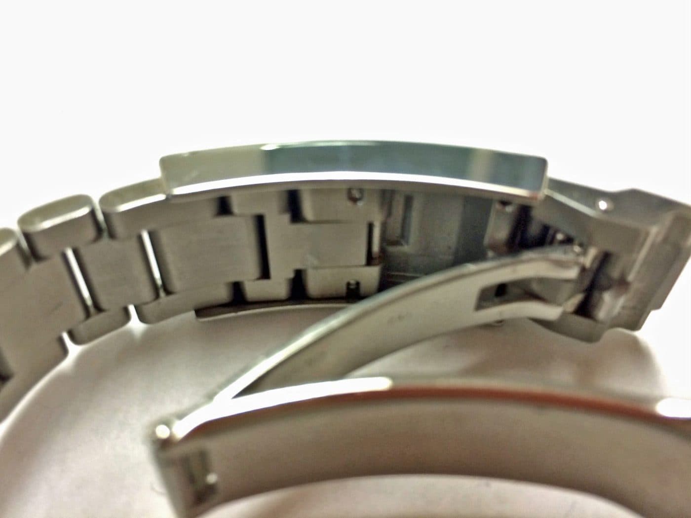 Side view of a steel Rolex Oyster bracelet with its Glidelock clasp open, showing the bracelet end sitting in the sliding rail under the polished clasp cover