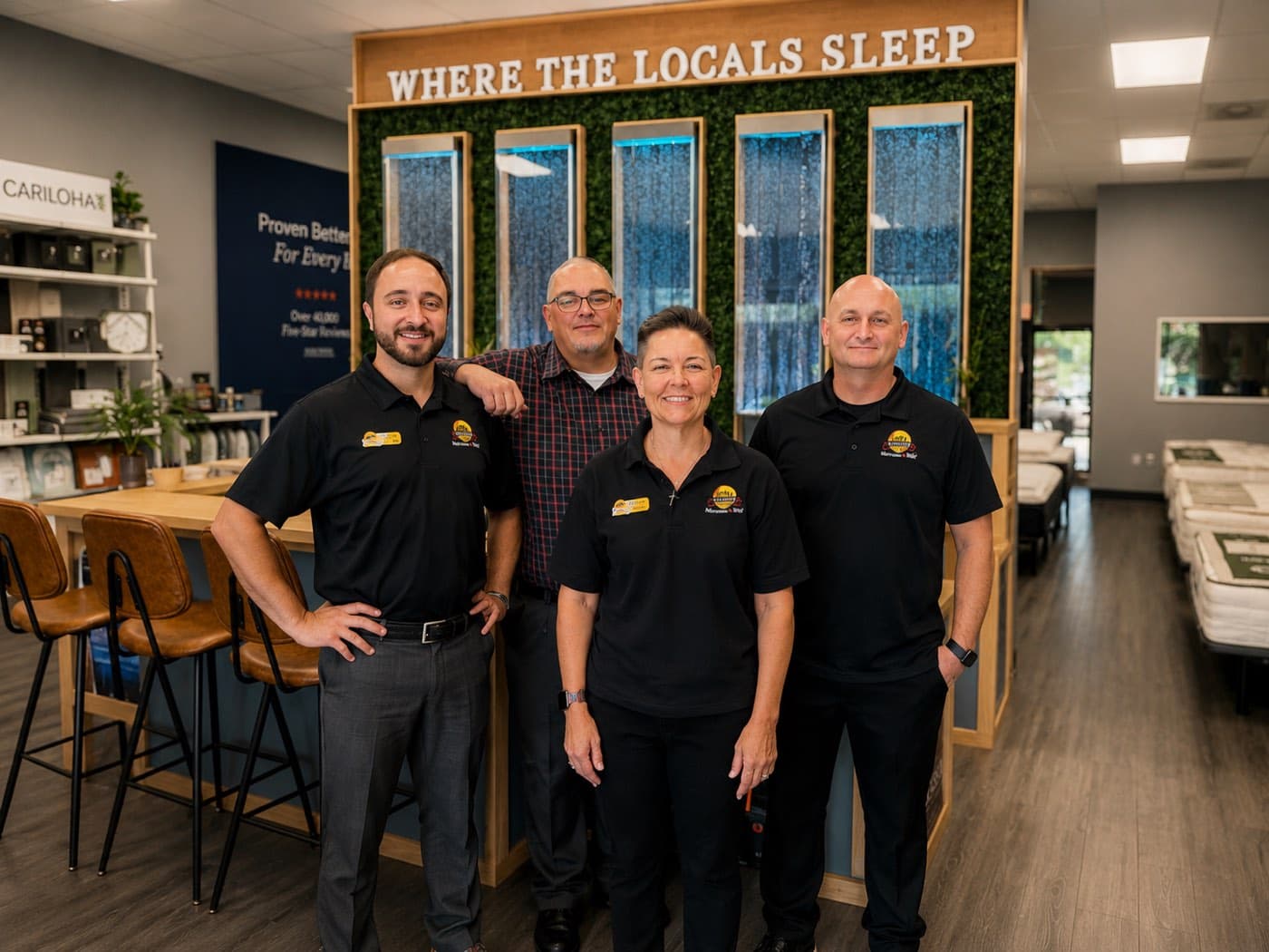 The Jacksonville Bedding team in the showroom, under the Where The Locals Sleep wall