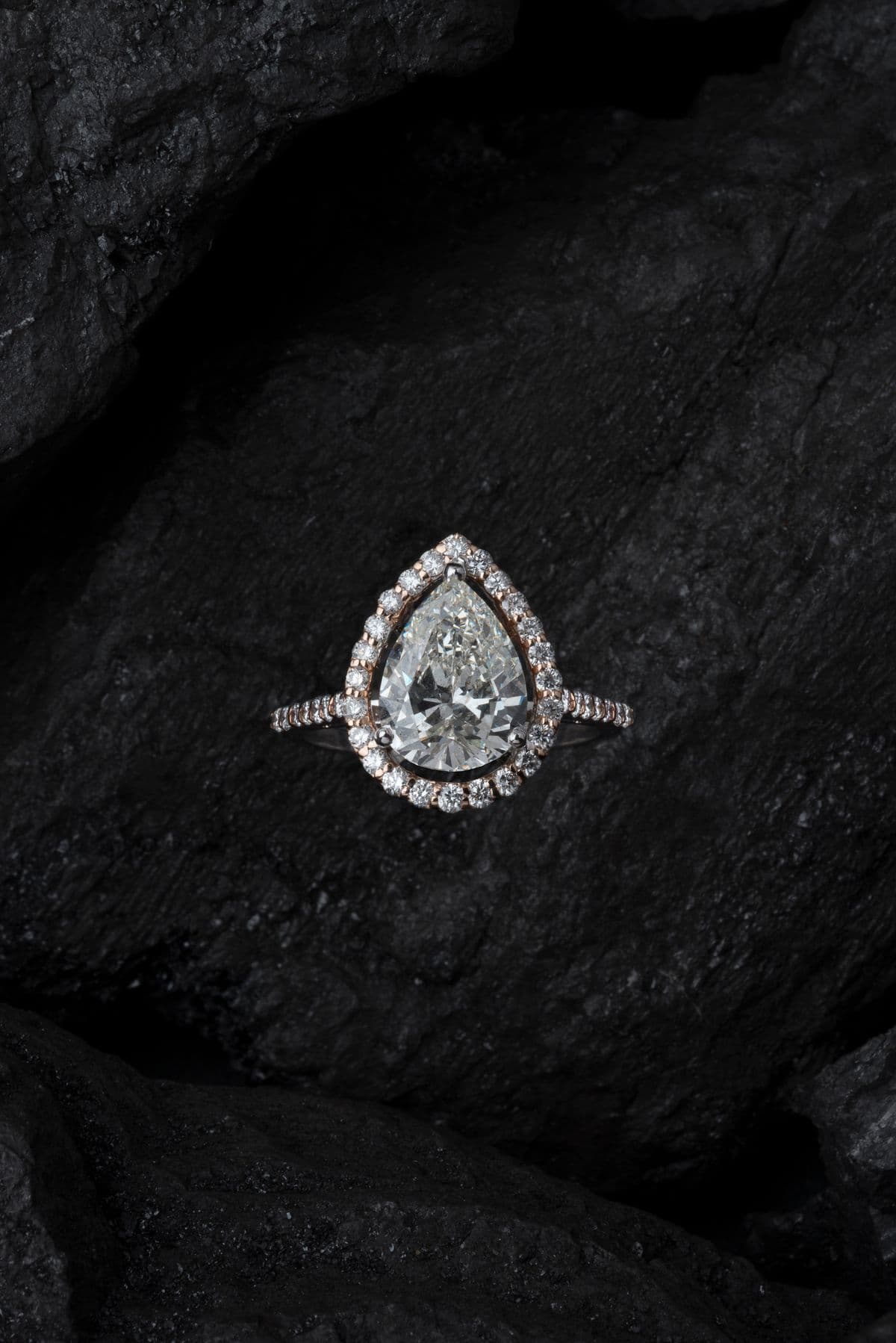 A diamond ring with pave stones sparkling on a dark surface