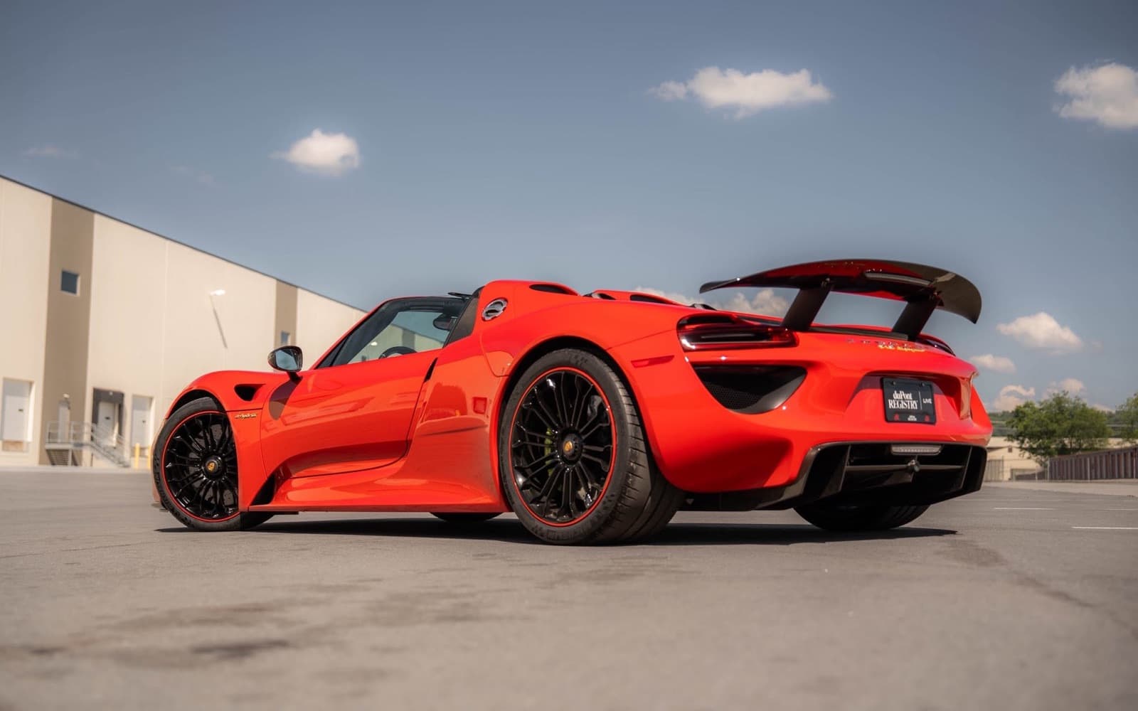 A red Porsche 918 Spyder wearing a duPont Registry plate