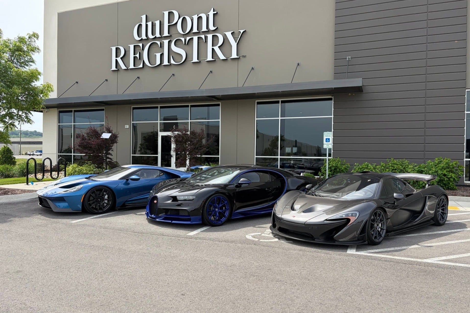 The duPont Registry storefront with a Ford GT, Bugatti Chiron, and McLaren P1 parked out front