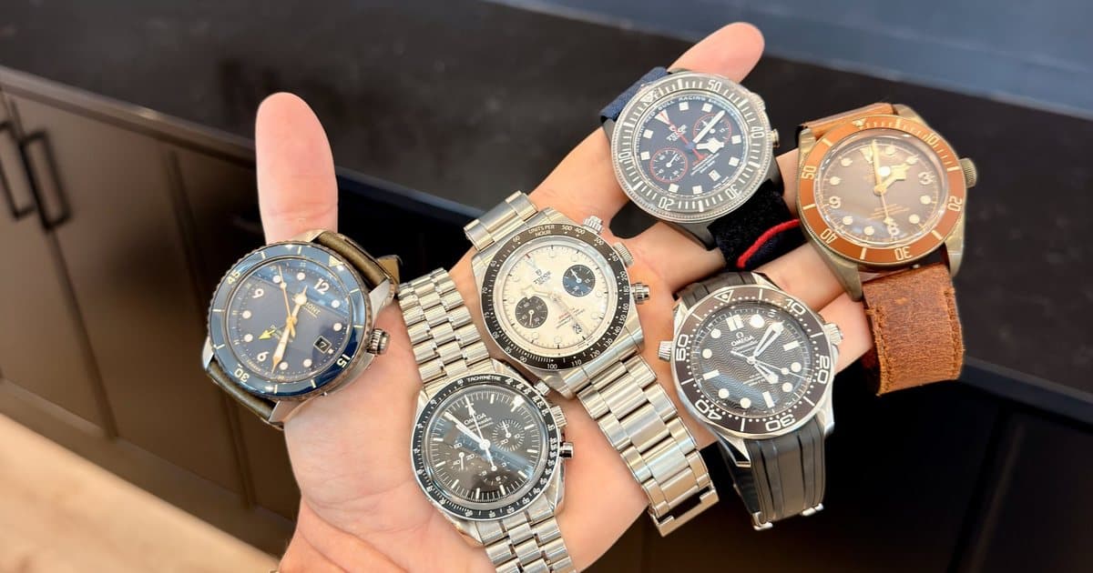 Vadim holding the six starting watches in one hand at the Moda office: a Bremont Project Possible, an Omega Speedmaster Professional, a Tudor Black Bay Chrono, a Tudor Pelagos FXD Chrono, an Omega Seamaster Diver 300M and a bronze Tudor Black Bay