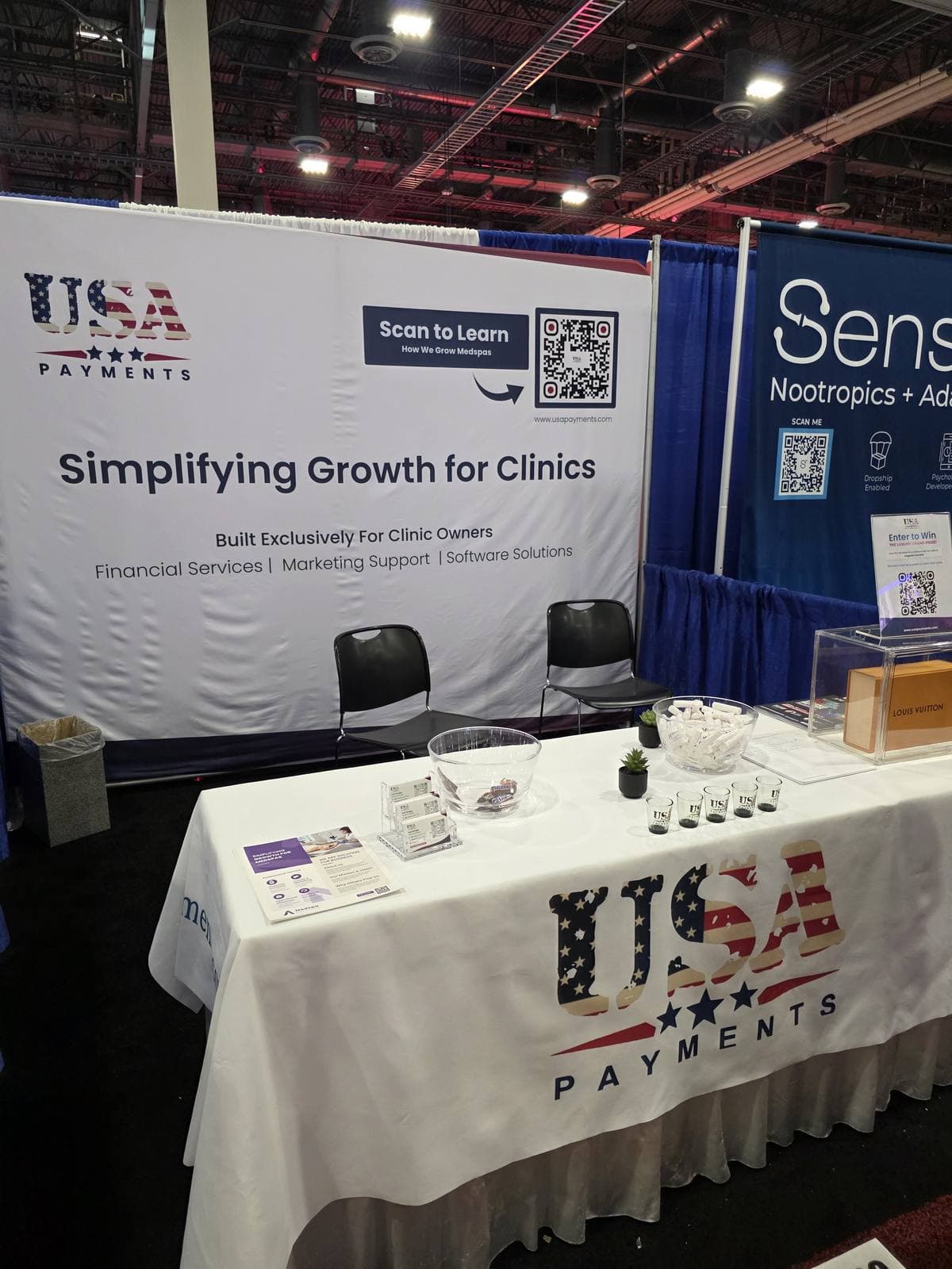 The USA Payments booth at an industry expo, with a branded banner and table