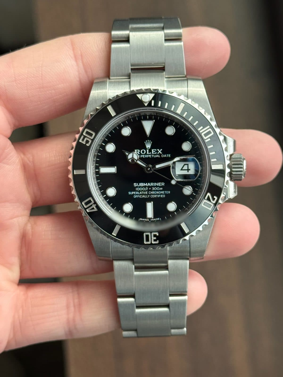 Rolex Submariner Date 116610LN with its black dial and black Cerachrom bezel, held in a hand