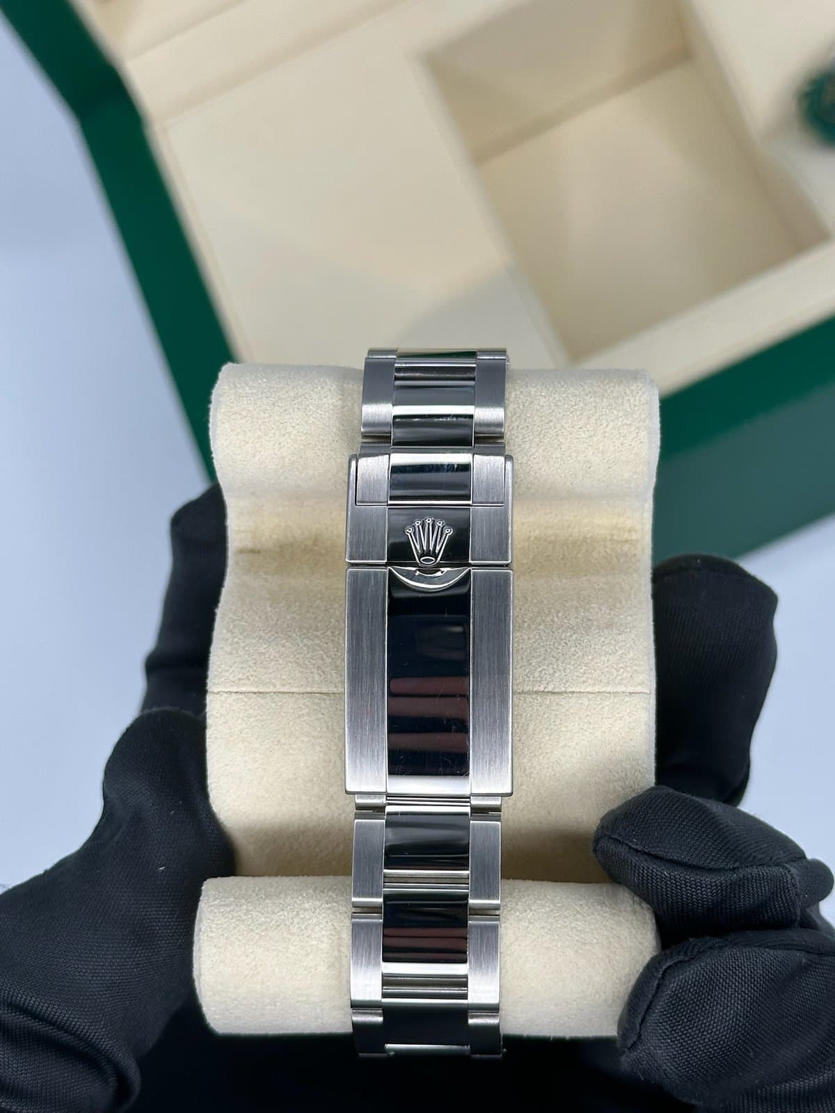 The closed Oysterlock clasp of a Rolex GMT-Master II 116710BLNR on its Oyster bracelet, wrapped around a cream watch pillow